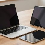 Ilustrasi laptop tipis dan tablet dengan keyboard terpisah di atas meja kayu